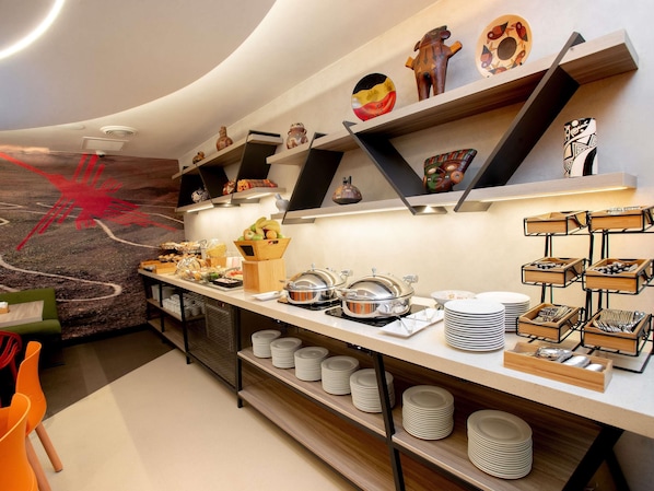 A modern breakfast buffet with various food items and decorative pottery.