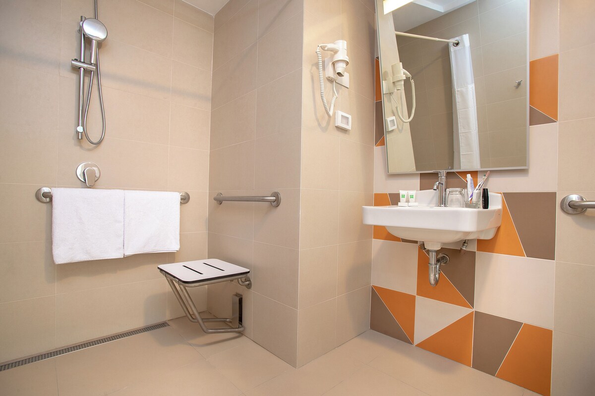 Une salle de bain moderne avec une douche, un lavabo et un miroir.