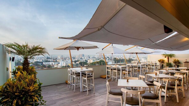 An outdoor terrace with tables and chairs, umbrellas, and potted plants. - ibis Styles Lima Benavides Miraflores Hotel (Lima)