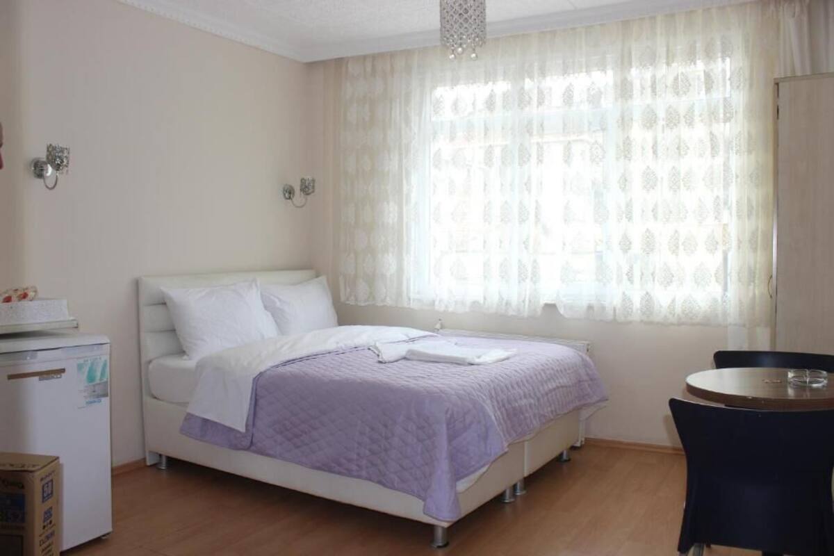 A bedroom with a bed, a small table, and a chair.
