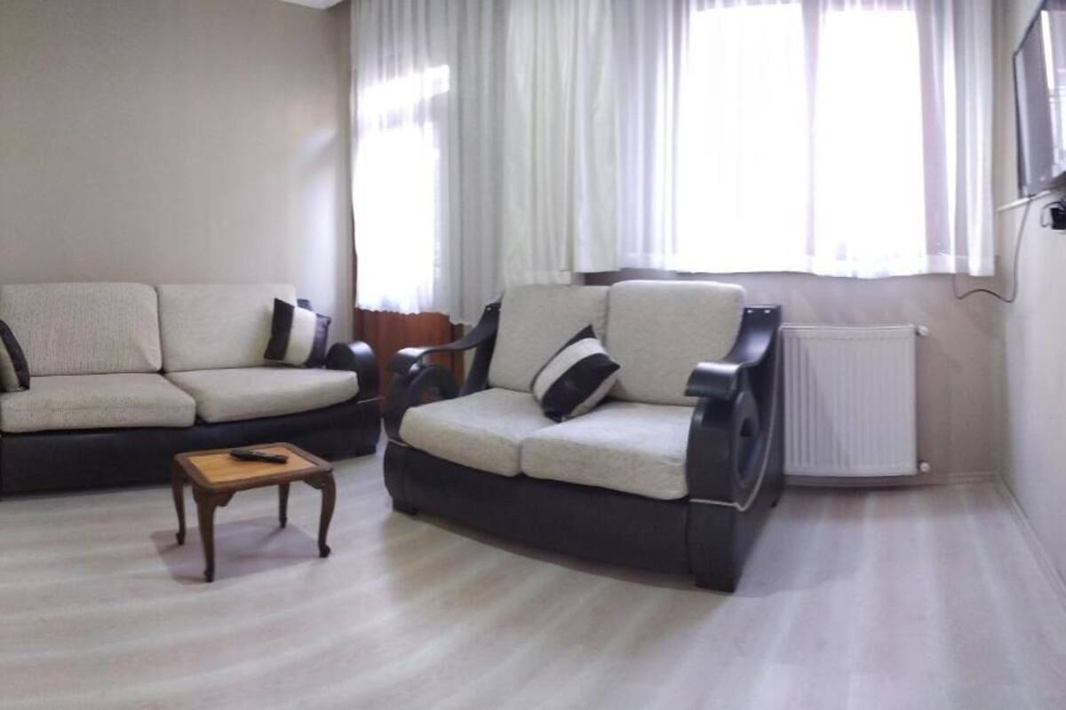 A living room with two sofas, a small wooden table, and a radiator.