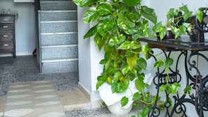 A staircase with a potted plant on the right and a framed picture above it. - Bed And Breakfast Villa Bianca (Orosei)