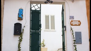A white building with a green door, a mailbox, and a number sign. - Bed And Breakfast Villa Bianca (Orosei)