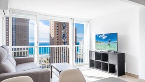 A modern living room with a balcony, a TV, a sofa, and a dining table. - Albatros 14-10 (Benidorm)