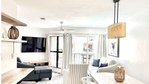 A modern living room with a sofa, a dining table, and a TV.