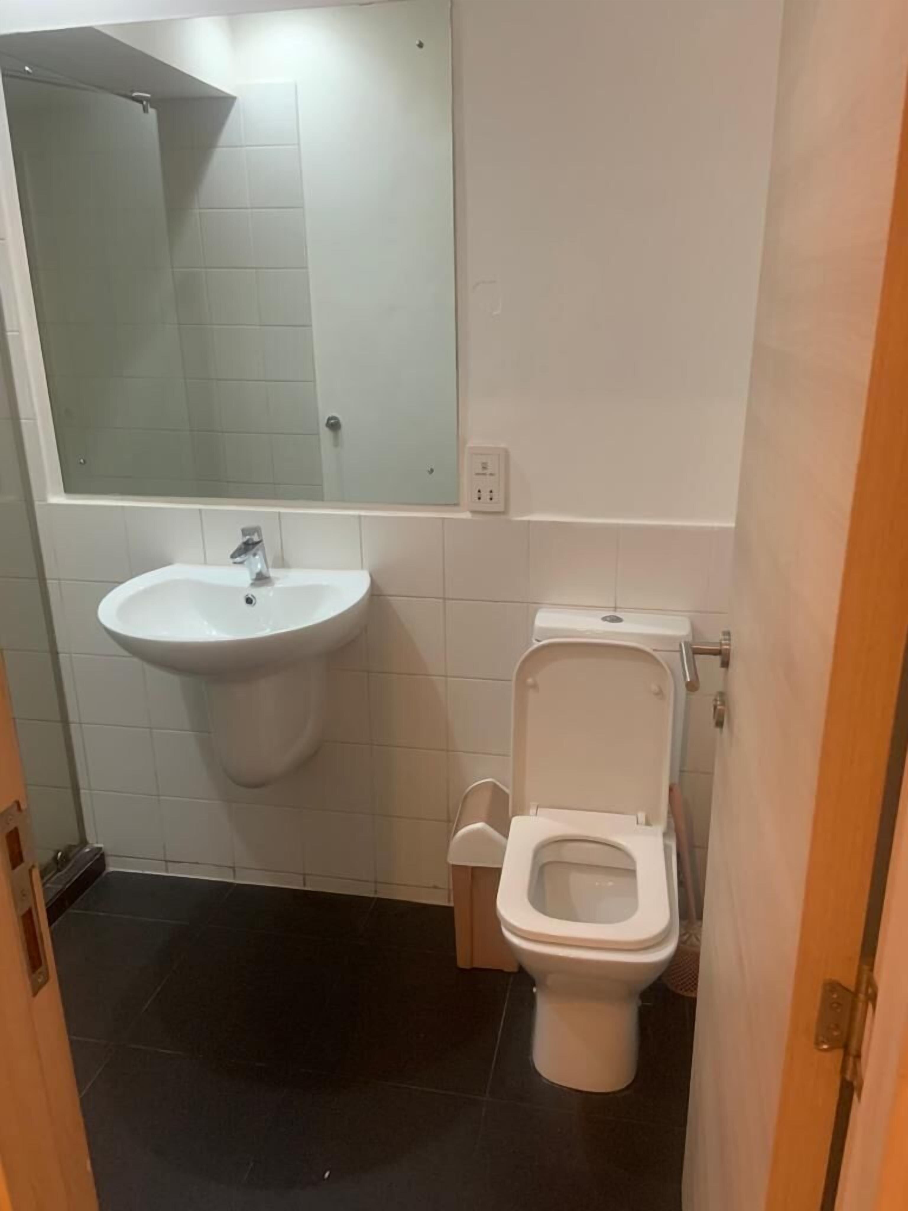 Un baño con un lavabo blanco, un espejo y un inodoro.