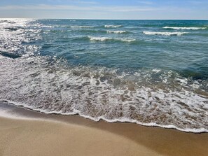 A beach with waves gently lapping onto the shore.