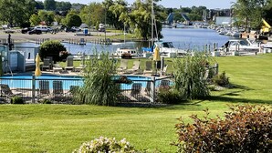 Un puerto deportivo con barcos amarrados, una piscina y una zona ajardinada.