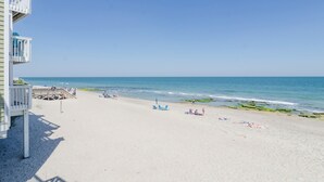 Ein Strand mit einer Holzterrasse und freiem Blick auf das Meer.