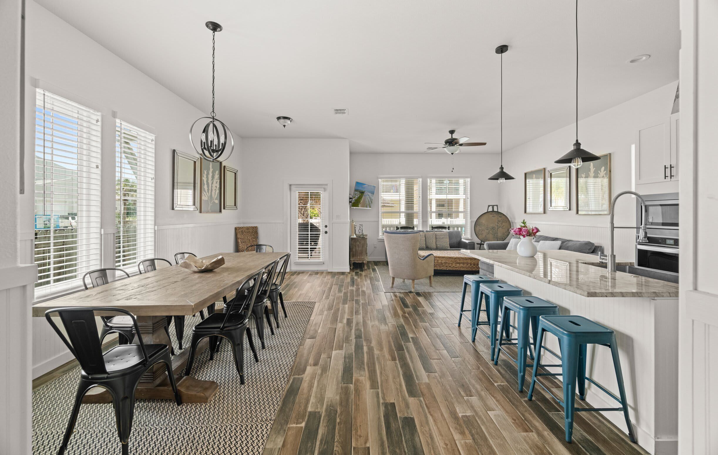 A spacious kitchen with a dining area, wooden flooring, and modern appliances.