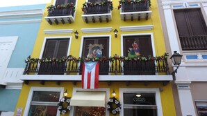 Een gebouw met meerdere balkons, versierd met bloemen en guirlandes.