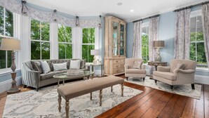 Un salon spacieux avec une grande fenêtre, un meuble en bois et un canapé.