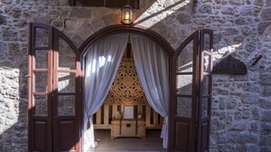 Una puerta de madera abierta con cortinas que da a una habitación con un cofre de madera y un letrero que dice "DECAN".