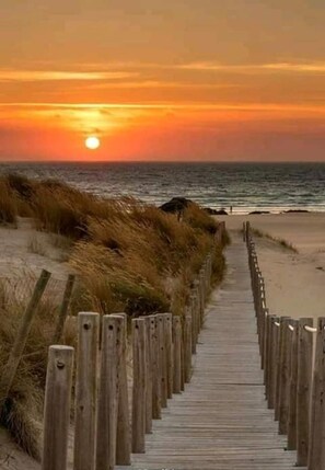 Una pasarela de madera que conduce a la playa con vistas al océano.