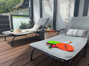 Two lounge chairs on a wooden deck with a view of a building and greenery. - A Romantic Getaway in the Harz Mountains: A Little Bit of Happiness Near Goslar (Goslar)