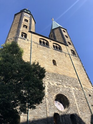 Una torre de piedra histórica con ventanas en arco y un reloj.