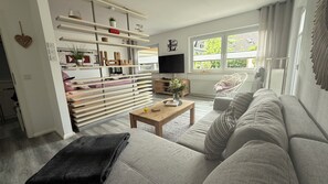 A modern living room with a sofa, coffee table, and built-in shelves. - A Romantic Getaway in the Harz Mountains: A Little Bit of Happiness Near Goslar (Goslar)