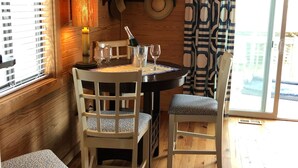 Un intérieur en bois avec une table à manger, des chaises et une fenêtre équipée de stores.