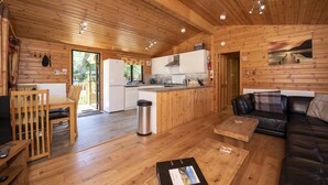 A wooden cabin with a kitchen, dining area, and living room. - Lomond Lodge 20, Luxury Log cabin on the banks of Loch Lomond (Loch Lomond)