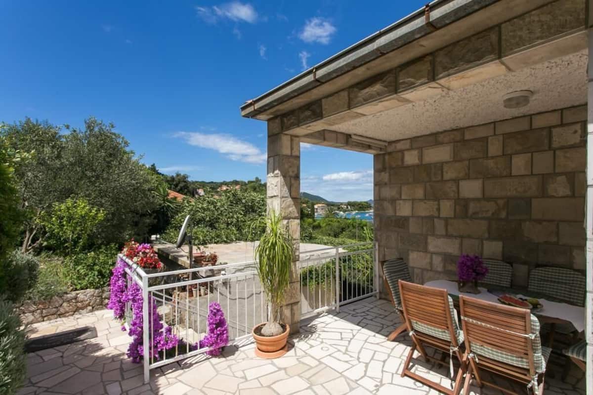 A stone patio with outdoor seating and a view of the countryside.