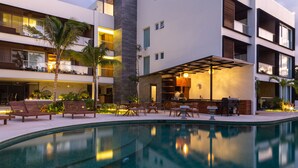 Un hôtel moderne doté d’une piscine, d’un espace extérieur aménagé et d’un bar.