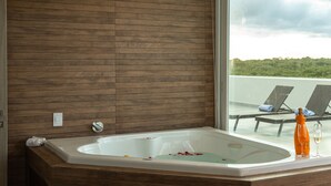 Une salle de bain moderne avec un mur en bois, une baignoire et une vue sur un balcon agrémenté de chaises longues.