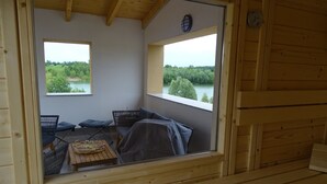 Une cabane en bois dotée d’un balcon donnant sur un lac.