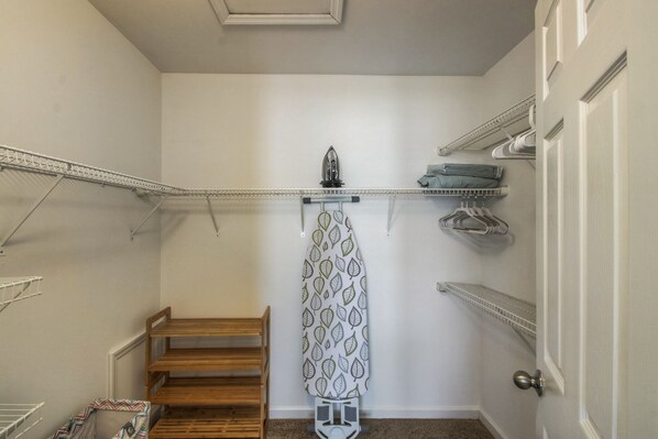 A laundry room with a wooden bench, ironing board, and hanging clothes rack. - A Hop, Skip and a Jump to it All! (Columbia)