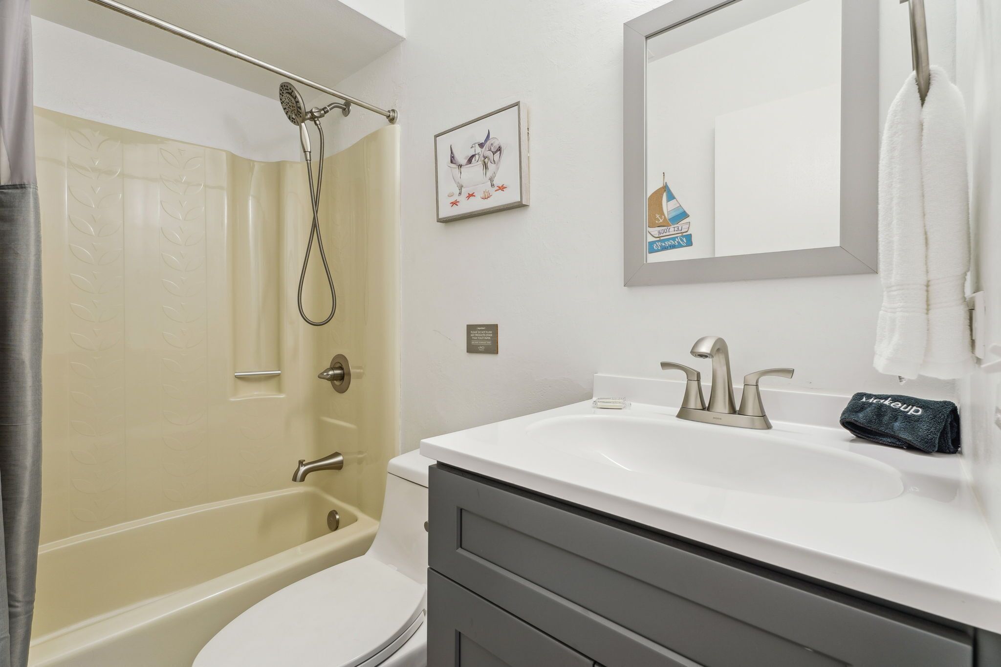 A bathroom with a bathtub, a sink, a mirror, and a towel rack.