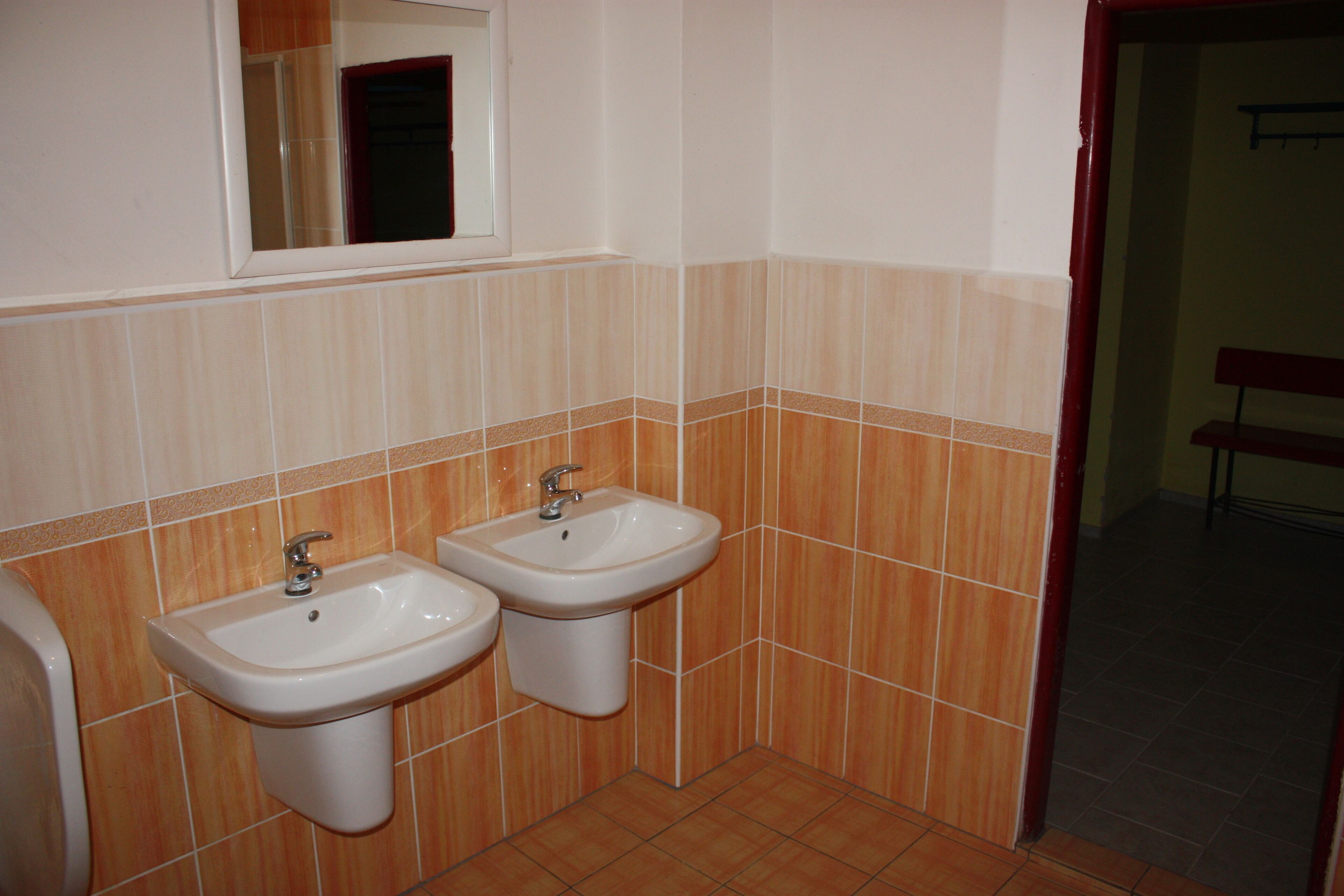 A bathroom with two sinks, a mirror, and tiled walls.