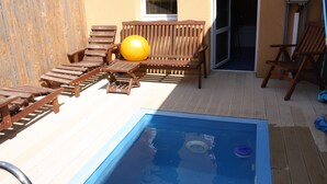 A pool area with wooden lounge chairs, a yellow exercise ball, and a small pool. - Sporthotel BK Pod Lipou (Vedomice)