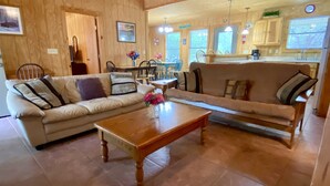 Una sala de estar acogedora con un sofá, una mesa de centro y un comedor con sillas y una mesa.