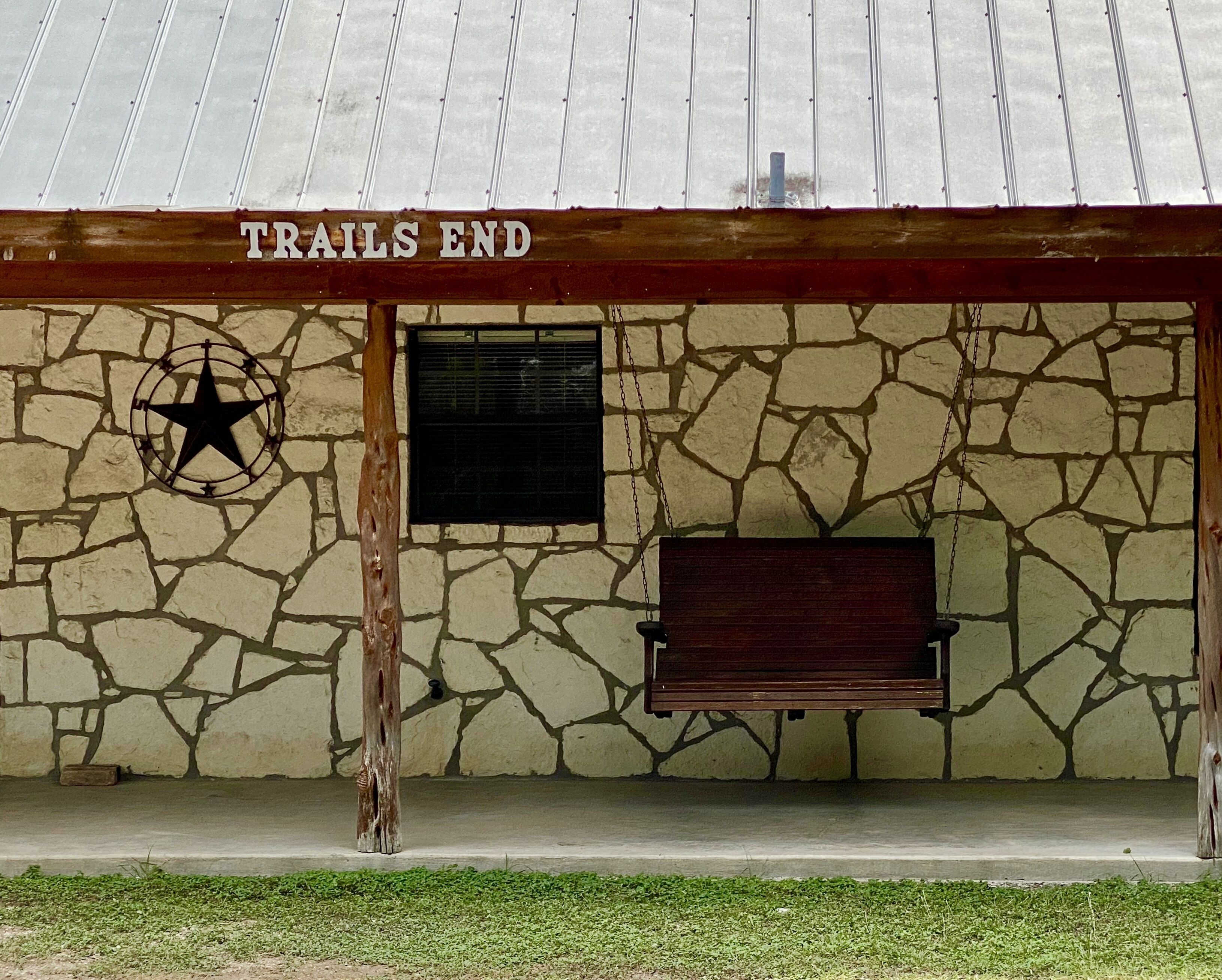 A stone building with a sign reading "TRAILS END" and a star symbol.