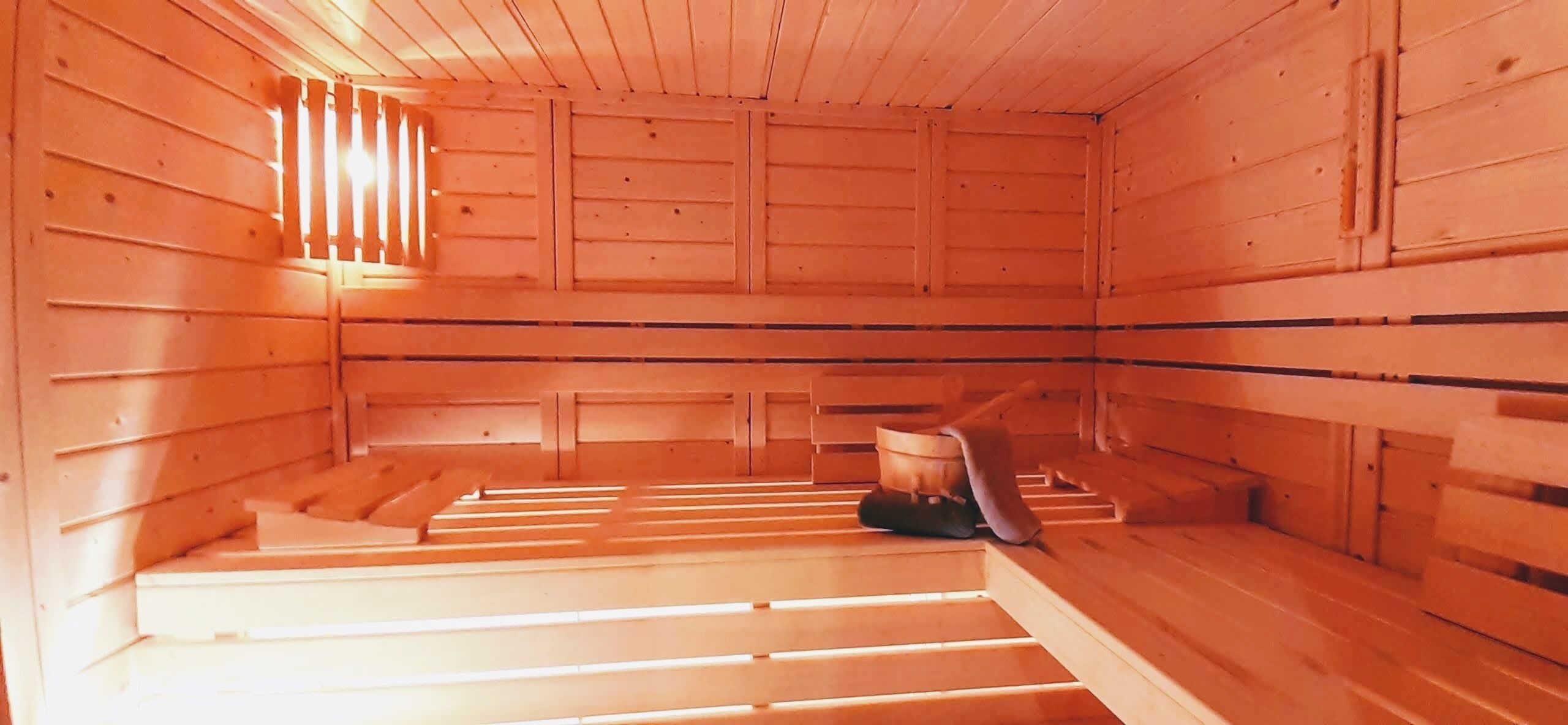 A sauna room with wooden walls and benches.