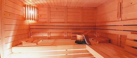 A sauna room with wooden walls and benches.