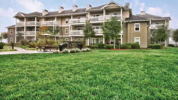 A multi-story residential building with balconies, a lawn, and outdoor seating. - Beautiful Resort in CA Wine region - Windsor! (Windsor)