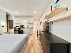 A compact hotel room with a bed, kitchenette, and a desk. - Beautiful & Cozy Studio Condo in Denver Tech Center (Greenwood Village)