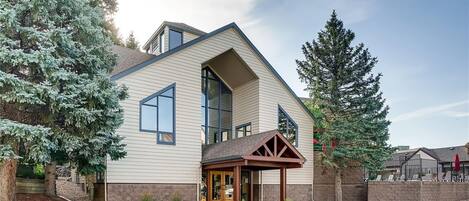 A modern two-story house with a large front porch, a garage, and a driveway.