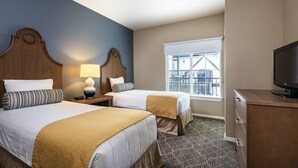 A hotel room with two beds, a TV, a window with a view, and a lamp. - Charming Resort in Breathtaking Solvang! (Solvang)