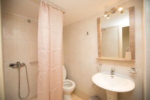 Ein Badezimmer mit Dusche, Toilette und Waschbecken.