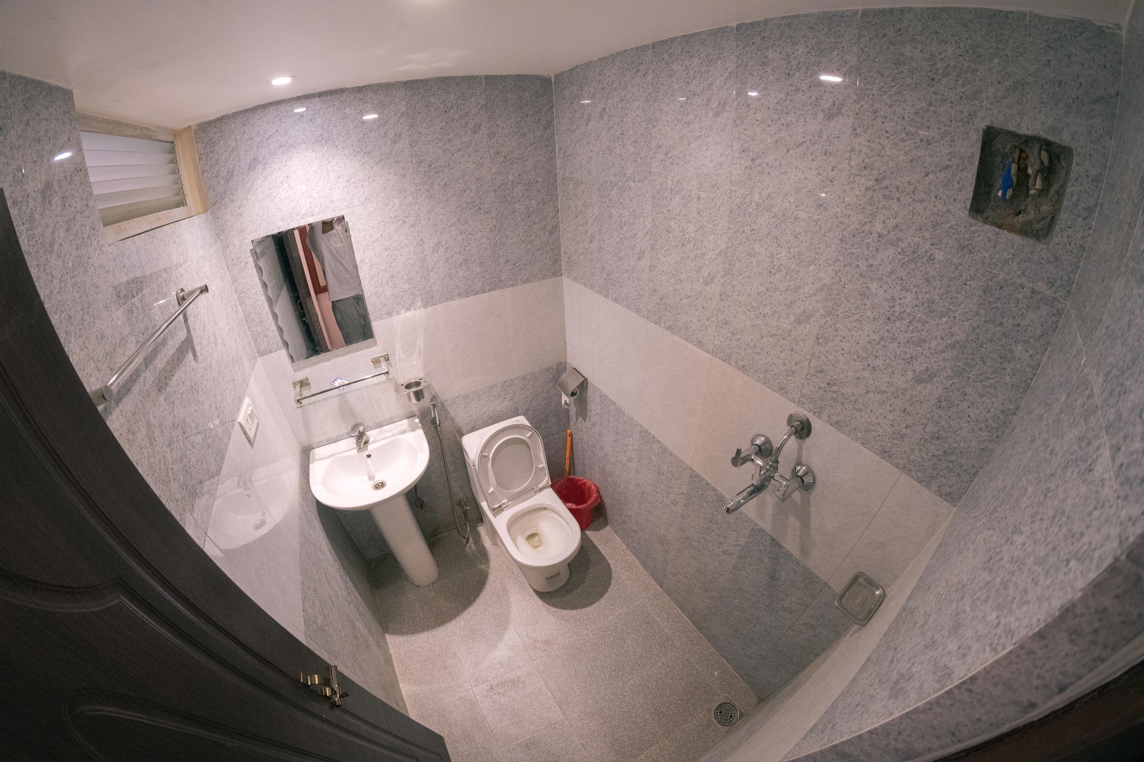 A bathroom with a toilet, sink, and shower area.