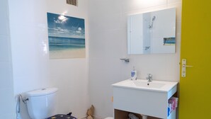 A bathroom with a toilet, sink, and mirror.