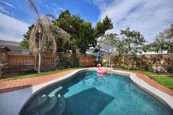 A backyard with a swimming pool, a wooden fence, and a wooden deck. - Near the Mayo Clinic and 6 blocks from Ocean 3 bedrooms Pool Home (Jacksonville Beach)