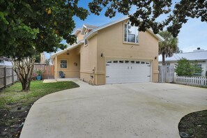 A two-story house with a beige exterior, a white garage door, and a well-maintained lawn. - Near the Mayo Clinic and 6 blocks from Ocean 3 bedrooms Pool Home (Jacksonville Beach)