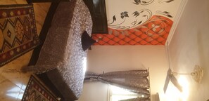 Experience a traditional room with a patterned bedspread, decorative wall, and ceiling fan.