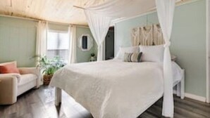 A bedroom with a canopy bed, a sofa, and a potted plant. - Rum Island Oasis - Springs Getaway! (Fort White)