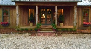 A wooden cabin with a porch, two windows, and a front door. - The Bridge: Melody House (St Francisville)