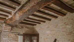 A bedroom with a bed, a wooden cabinet, a floor lamp, and a green chair. - La casa in piazzetta in Borgo Loretello (Loretello)