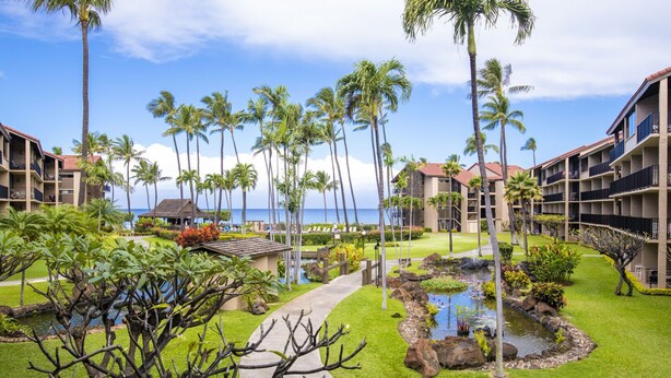 A resort with multiple-story buildings, a central pathway, and a small water feature. - Timeless island charm and breathtaking views (Lahaina)