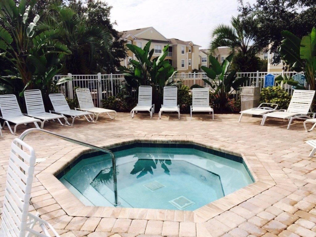 A swimming pool area with lounge chairs and a brick border.